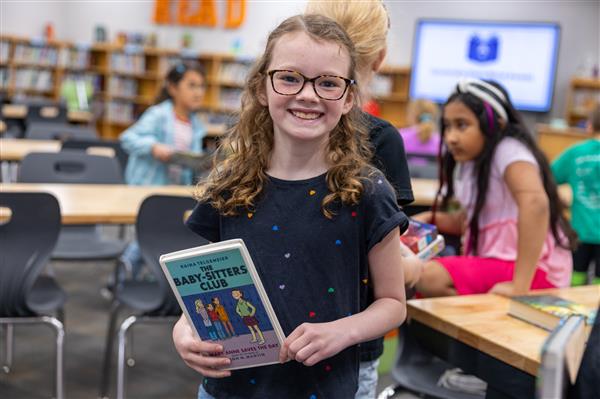 girl smiling while holding book